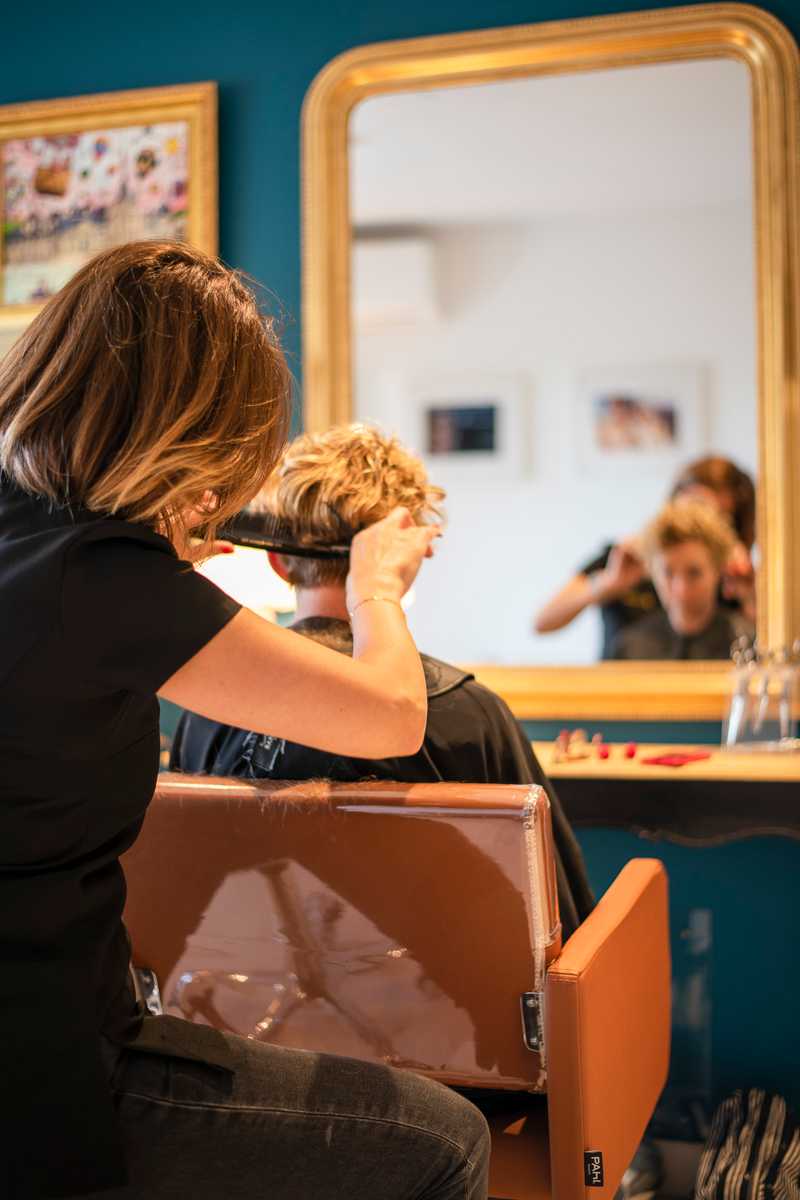 La coiffeuse coupant les cheveux d'une cliente